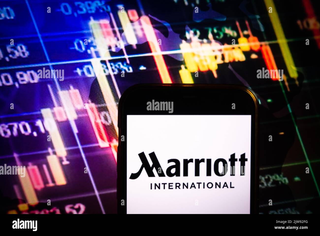 KONSKIE, POLONIA - 30 agosto 2022: Smartphone che mostra il logo della società Marriott International sullo sfondo del diagramma di borsa Foto Stock