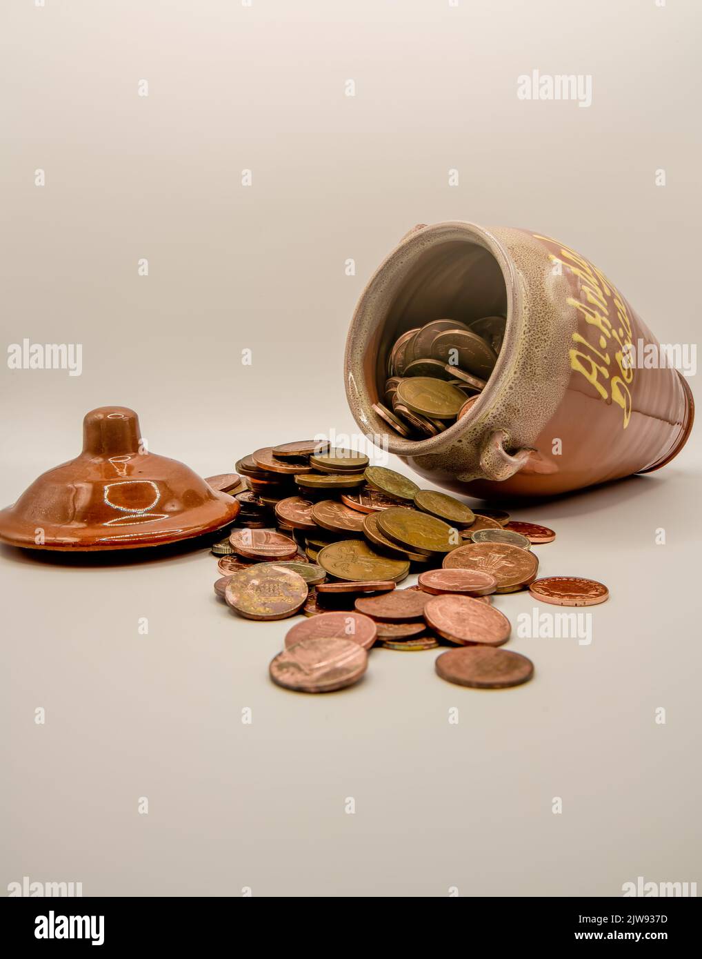 un mucchio di monete di rame accanto al vasetto di ceramica di miele da soldi, "chi ha rubato il denaro, miele?" Foto Stock