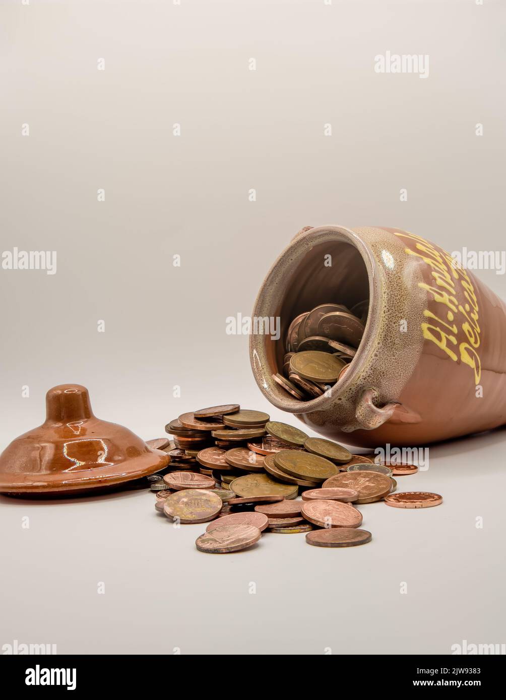 un mucchio di monete di rame accanto al vasetto di ceramica di miele da soldi, "chi ha rubato il denaro, miele?" Foto Stock