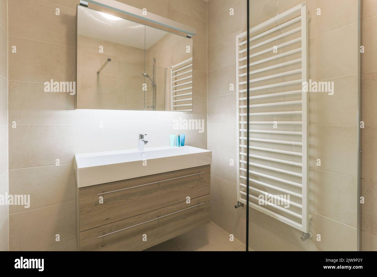 Interni di bagno contemporaneo con pareti e divisori beige scablato. Foto Stock