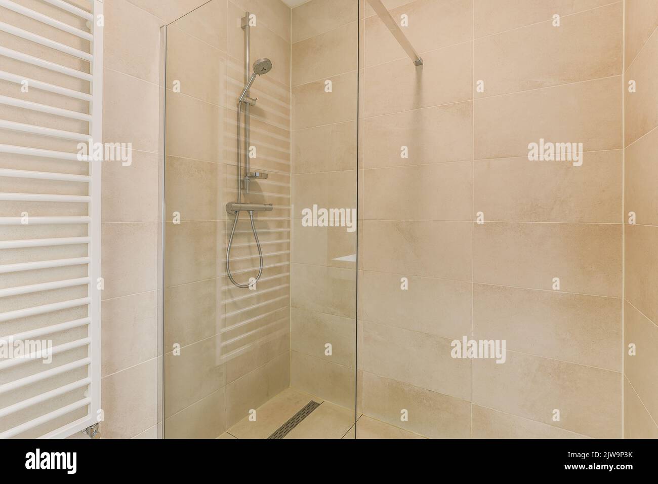 Interni di bagno contemporaneo con pareti e divisori beige scablato. Foto Stock