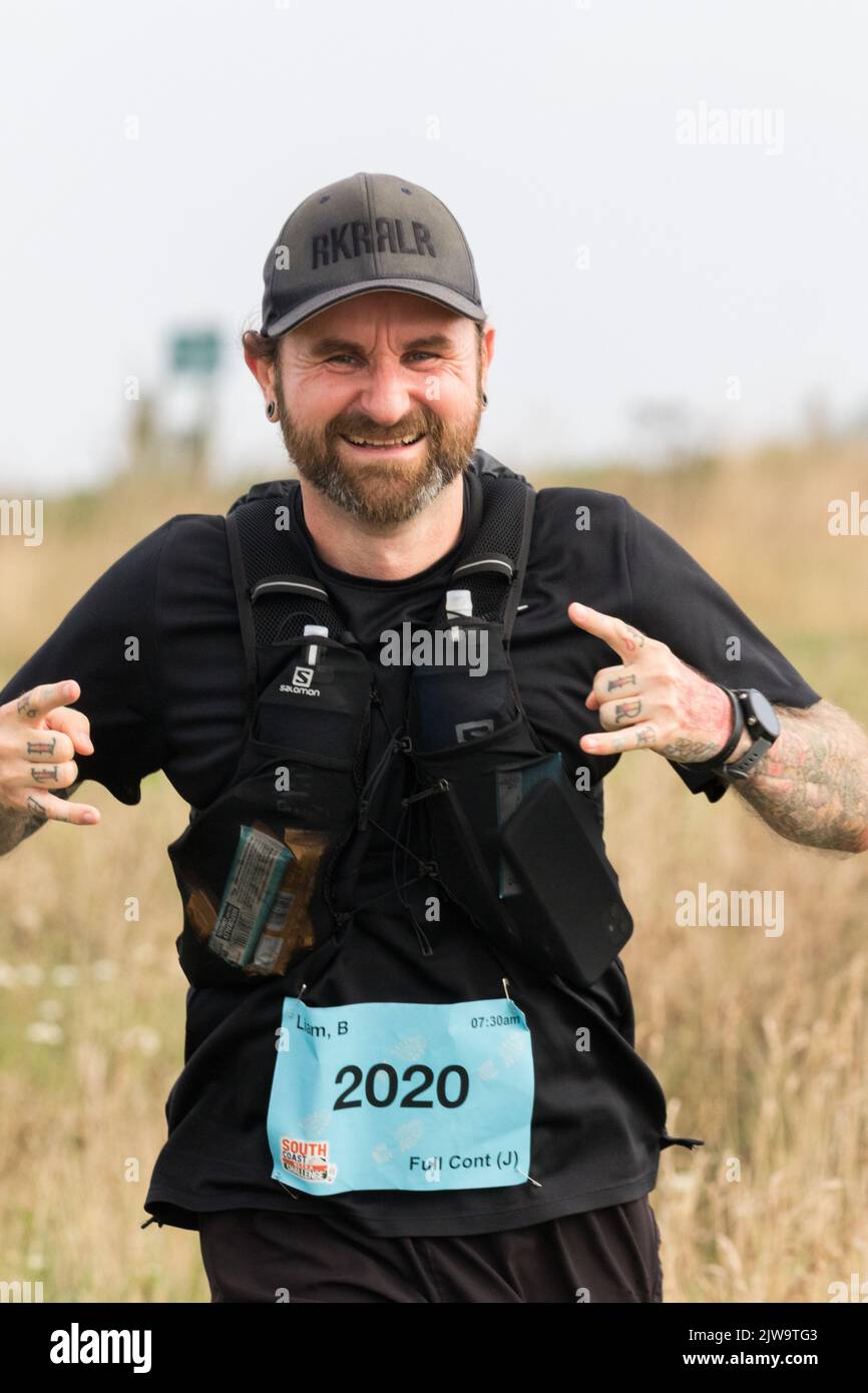 I corridori e gli escursionisti iniziano la sfida della costa meridionale per le loro associazioni di beneficenza scelte. Ogni partecipante completerà un 100km, un 57km, un 43km. Foto Stock