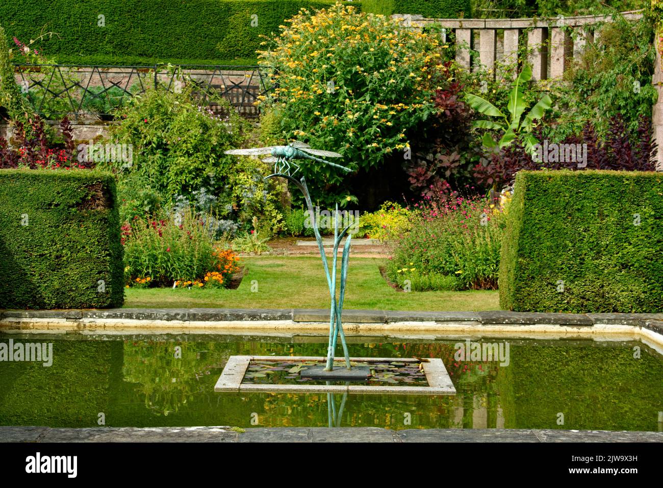 CASTELLO DI CRATHES BANCHORY SCOZIA GIARDINO MURATO DRAGONFLY SCULTURA E STAGNO IN TARDA ESTATE Foto Stock
