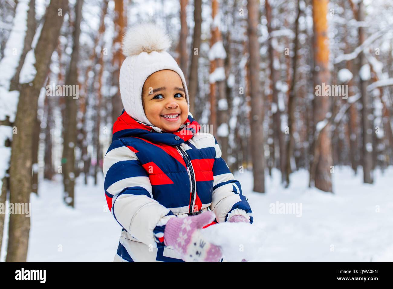 bambina che gioca nella nevosa giornata invernale nel parco in slitta giù per la collina Foto Stock