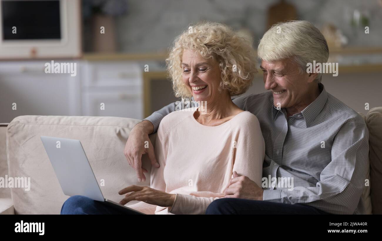 Felice coppia matura romantica rilassarsi sul divano di casa insieme Foto Stock