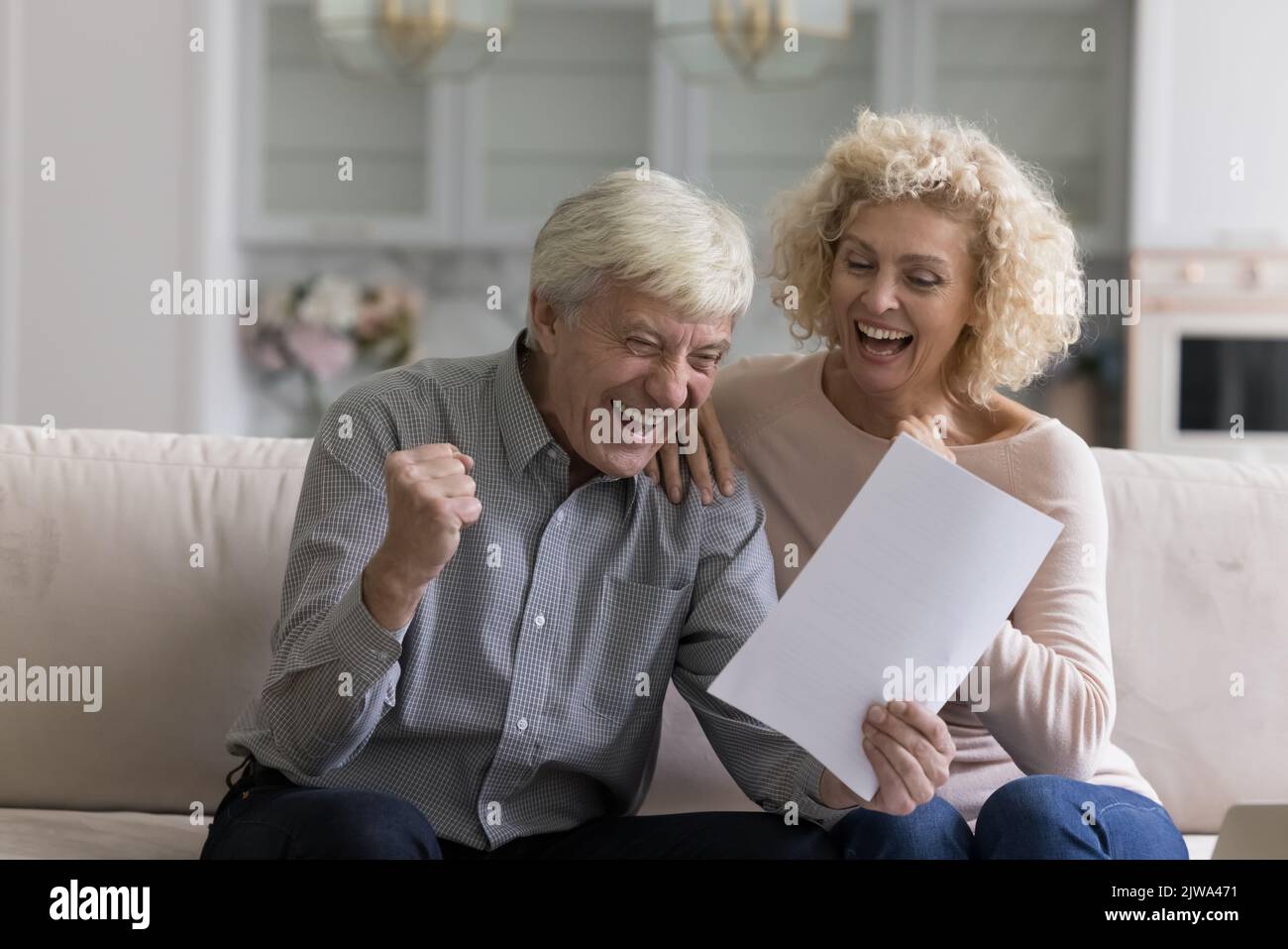 Felice eccitato senior pensionato coppia lettura documento cartaceo Foto Stock