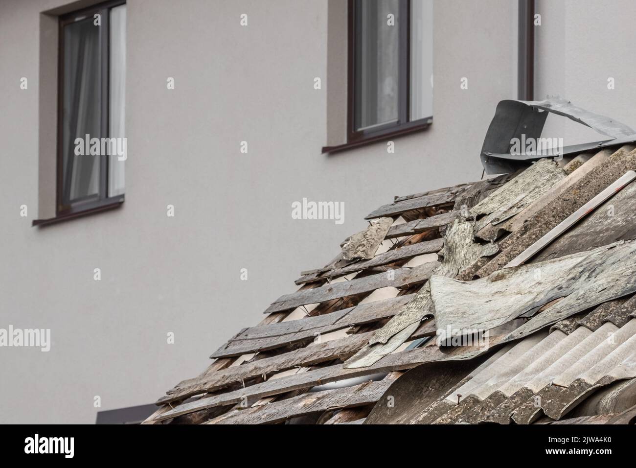 Tetto rovinato. Conseguenze dell'onda d'esplosione. Abitazioni sopravvissute. Ricostruzione di città e villaggi. Ardesia strappata. Foto Stock