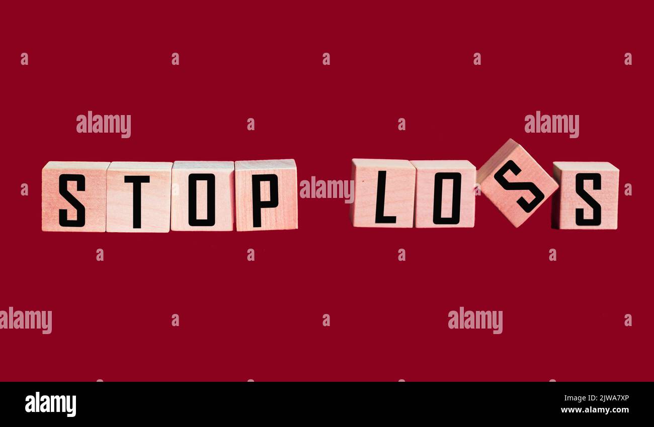 Stop Loss scritto su blocchi di legno su sfondo rosso Foto Stock