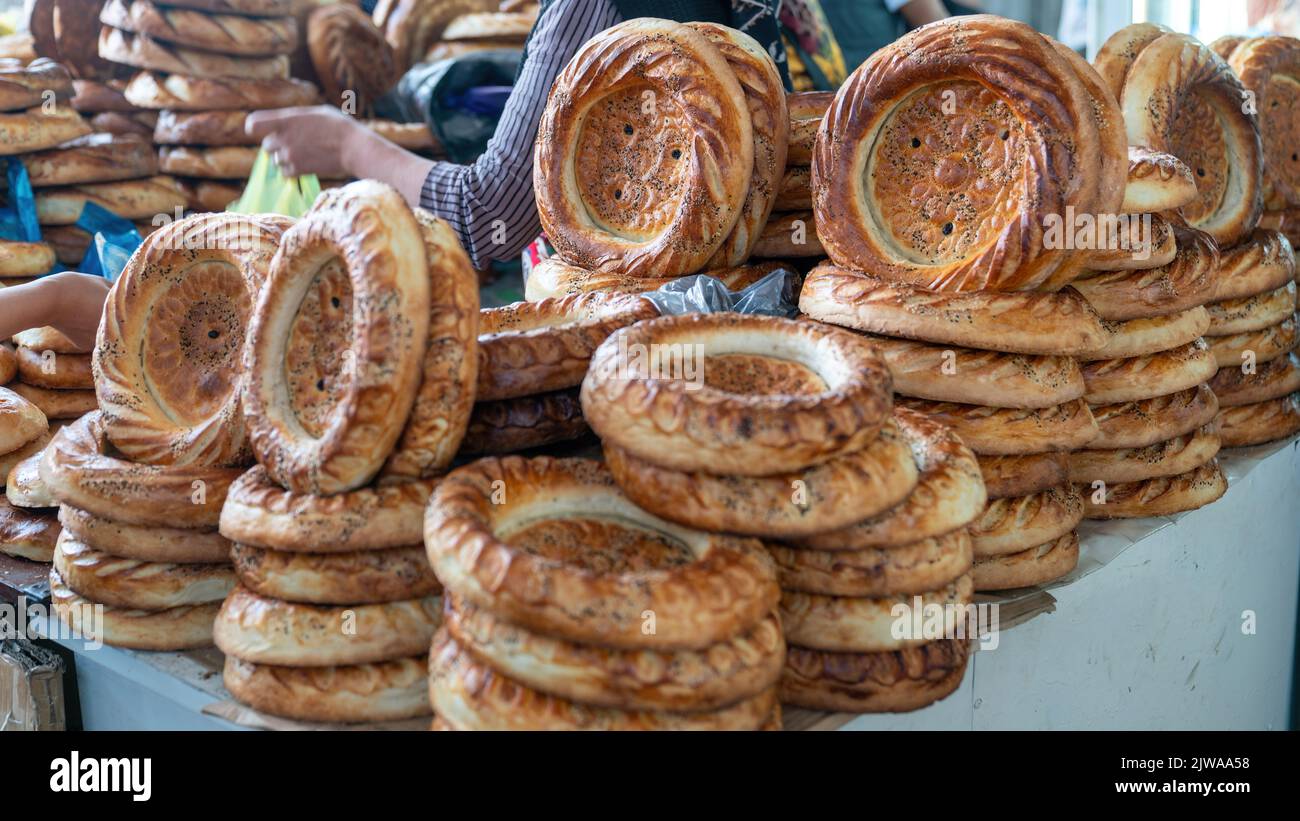 Pane Naan circolare e piatto fatto in un forno tandoori, una consuetudine asiatica centrale, OSH bazar locale, Kirghizistan. Foto Stock