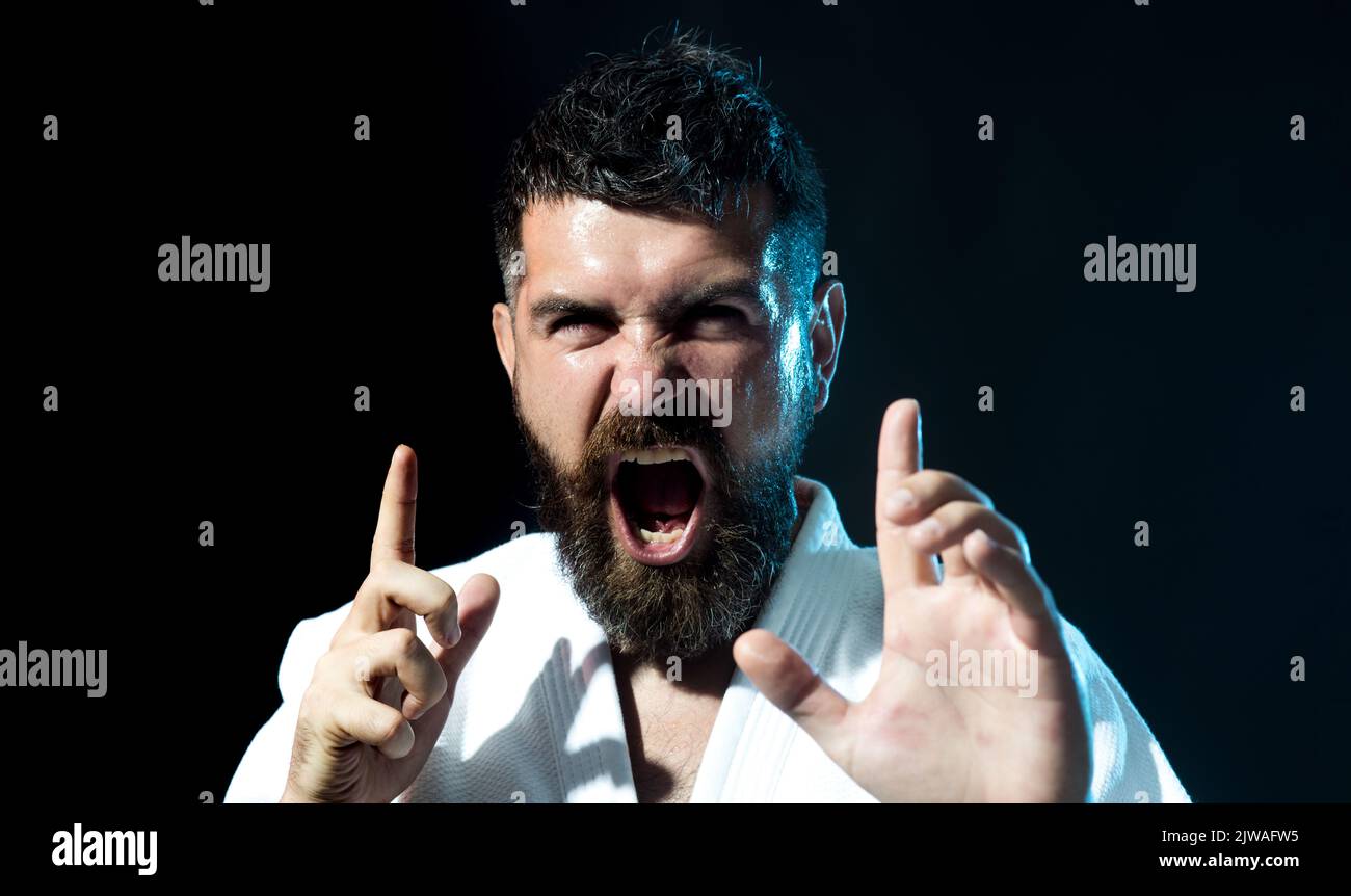 Karate uomo in kimono esercizio di sport da combattimento. Master arti marziali in allenamento lotta in palestra. Foto Stock