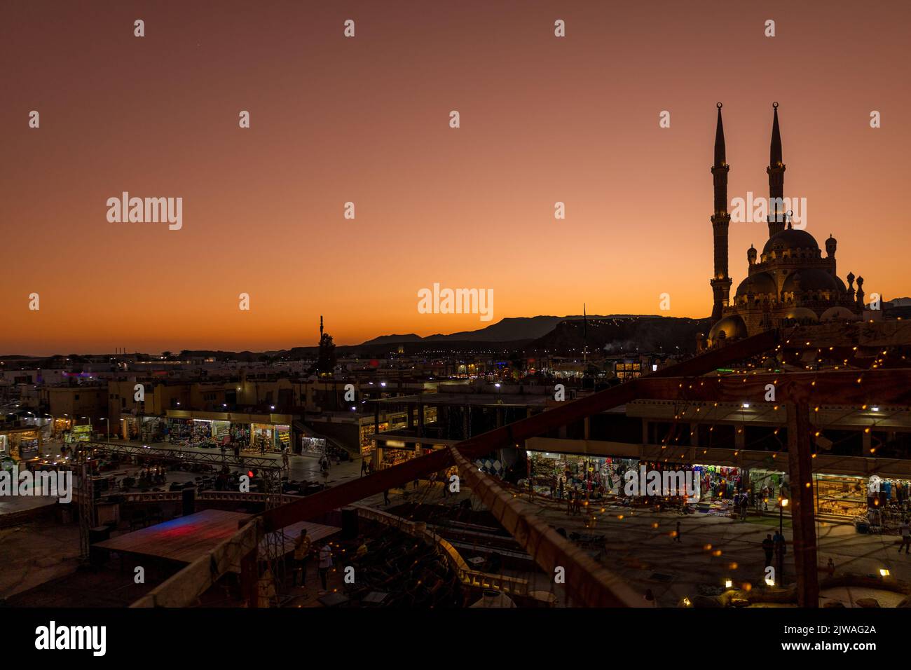 Vista panoramica dall'alto della moschea di al Sahab e della città vecchia al tramonto. Silhouette di persone nell'area dello shopping con souvenir in luci notturne, Sharm El Sheikh, Egitto. Foto di alta qualità Foto Stock