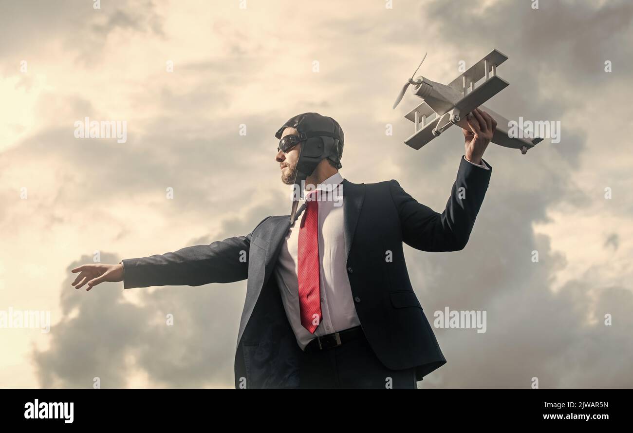 uomo d'affari in abito e cappello pilota lancia giocattolo aereo. concetto di progresso Foto Stock