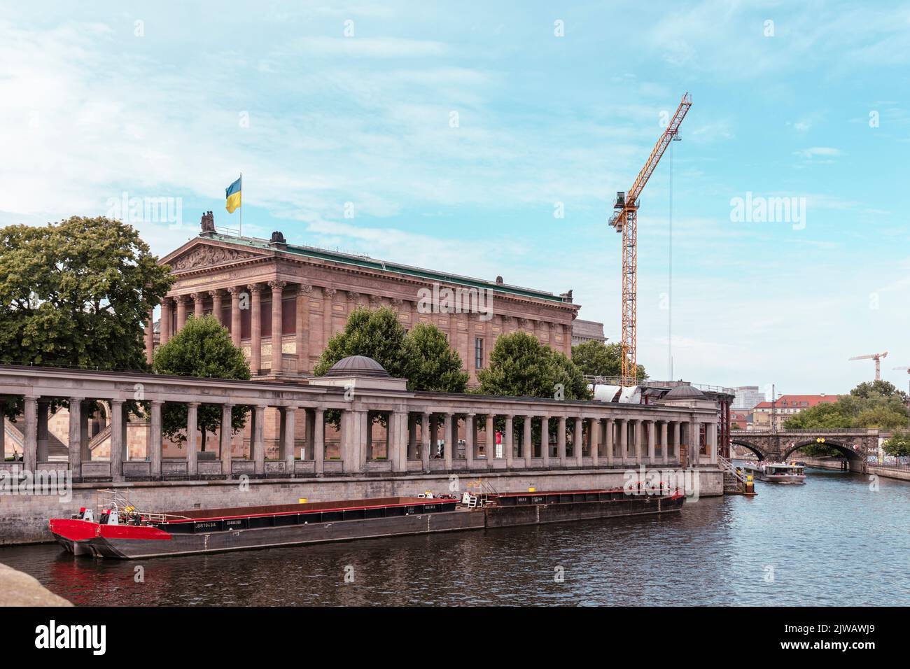 Berlino, Germania, 22 luglio 2022: Una chiatta pesante sul fiume Sprea a Berlino.sullo sfondo il Museo delle Arti con una bandiera ucraina Foto Stock