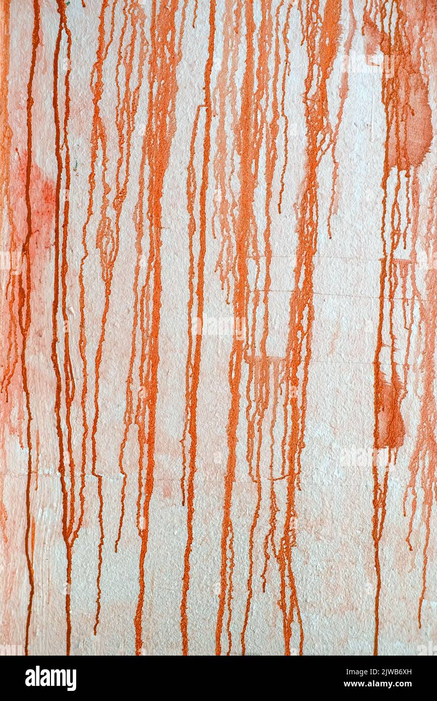 Texture di giù flussi di vernice arancione gocciolando giù il muro. Sfondo creativo, elemento di disegno astratto, spazio di copia Foto Stock