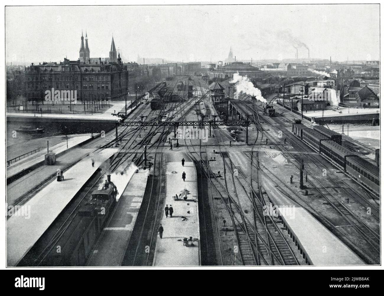 Vista del cantiere sul lato ovest della stazione H.S.M. Amsterdam et al. Di Amsterdam, dalla cappa della piattaforma, con l'edificio amministrativo della H.IJ.S.M. con la sinistra sullo sfondo. Sull'essiccatore. Foto Stock