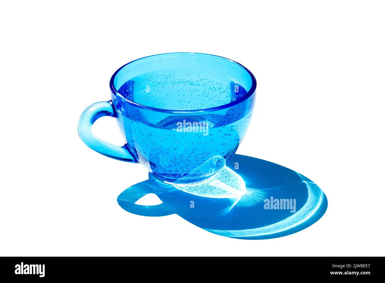 Un bicchiere d'acqua blu con forte ombra, isolato su sfondo bianco. Foto Stock
