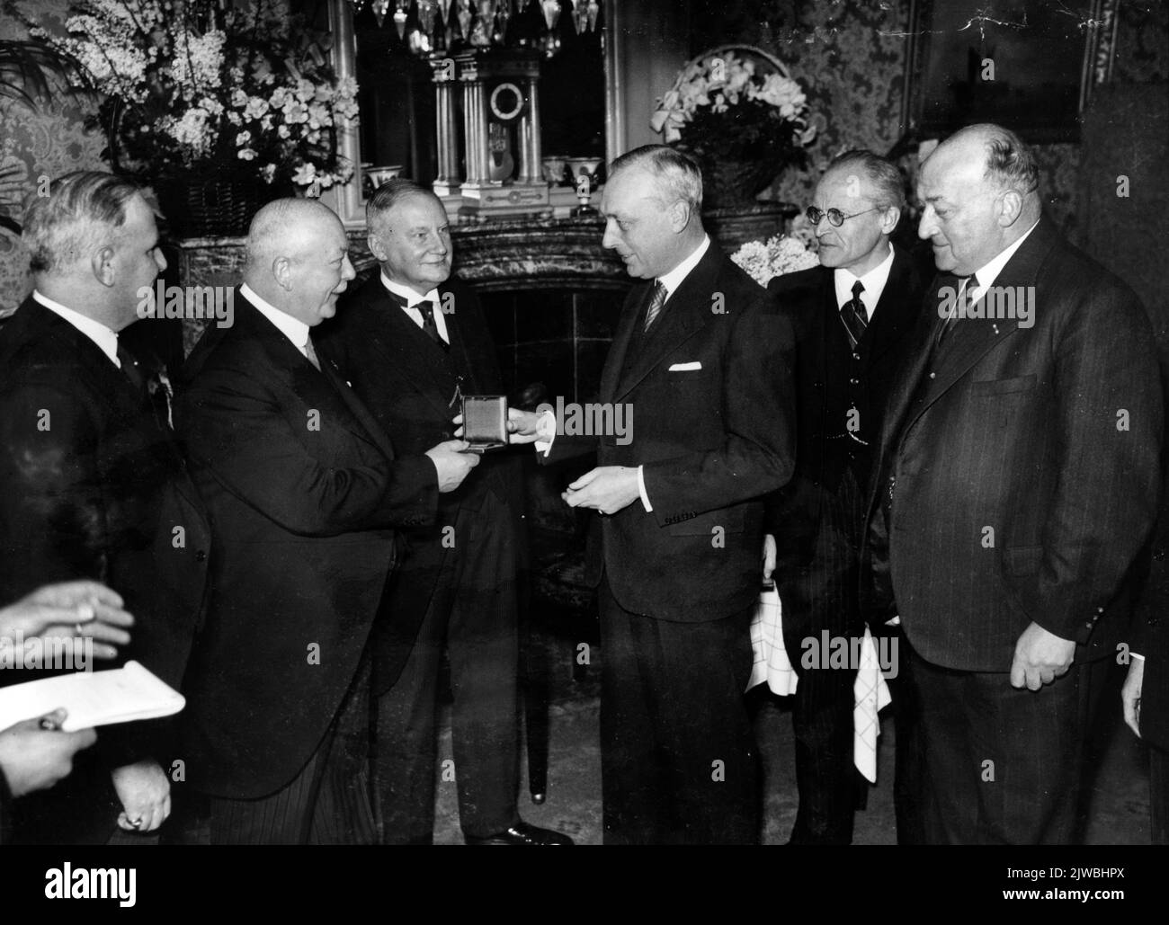 Immagine di F.H. Fentener van Vlissingen, presidente generale della Camera di Commercio e delle fabbriche di Utrecht, che trasmette le sue congratulazioni, e consegna una medaglia d'argento dorato, alla direzione della N.V. Maatschappij per la produzione e la consegna di materiali da costruzione degli eredi del viaggio durante il giubileo sia del 50th° anniversario della Legal Form N.V. che del 120th° anniversario della società. Foto Stock