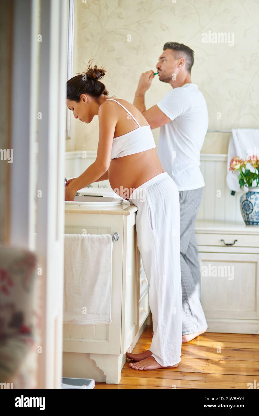 La loro routine mattutina: Un marito e una moglie si lavano i denti insieme in bagno. Foto Stock