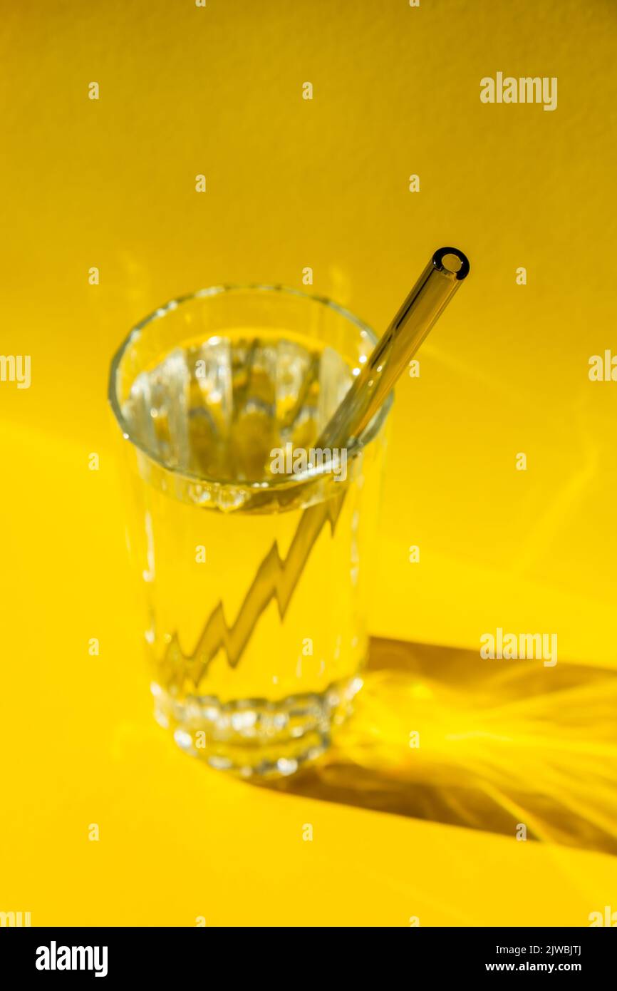 Cannucce in vetro riutilizzabili con acqua su sfondo giallo Set di cannucce per bevande ecologico con spazzola per la pulizia. Concetto senza rifiuti, senza plastica. Stile di vita sostenibile. Soggiorno senza rifiuti bassa rifiuti Foto Stock