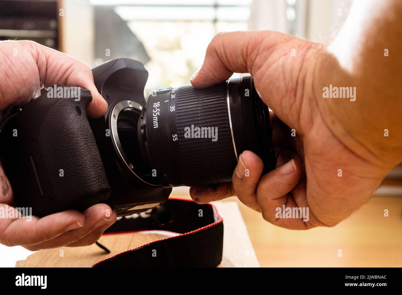 Fotografo maschile che posiziona un obiettivo standard su una fotocamera professionale. Foto Stock