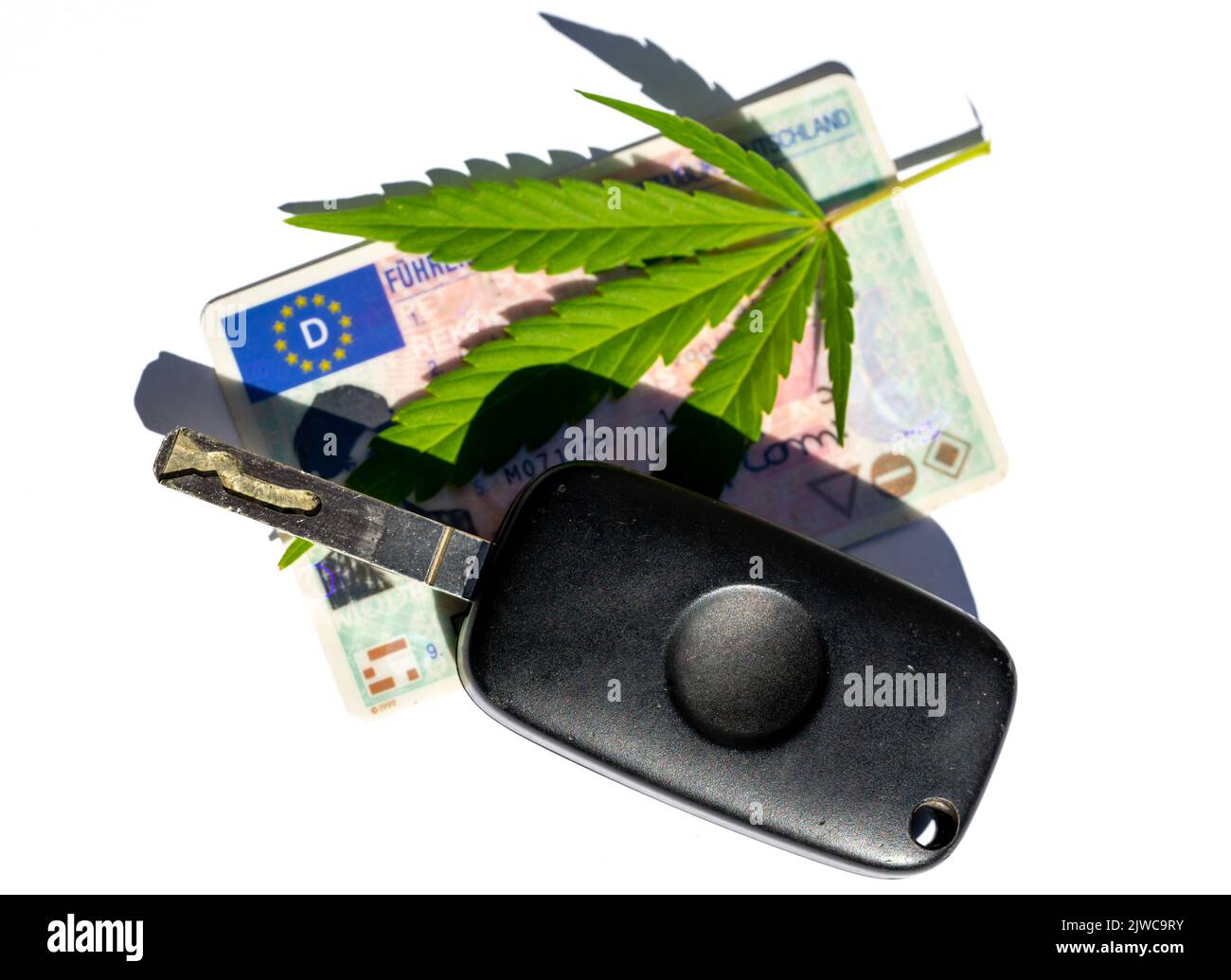 Foglia di cannabis con chiavi dell'auto e patente di guida Foto Stock