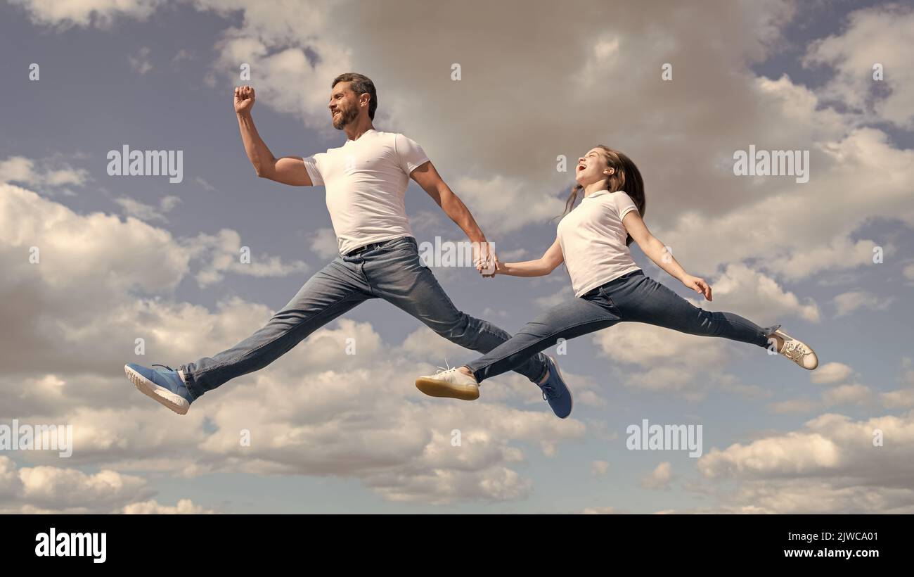 felice padre e figlia saltano nel cielo. stile di vita attivo Foto Stock