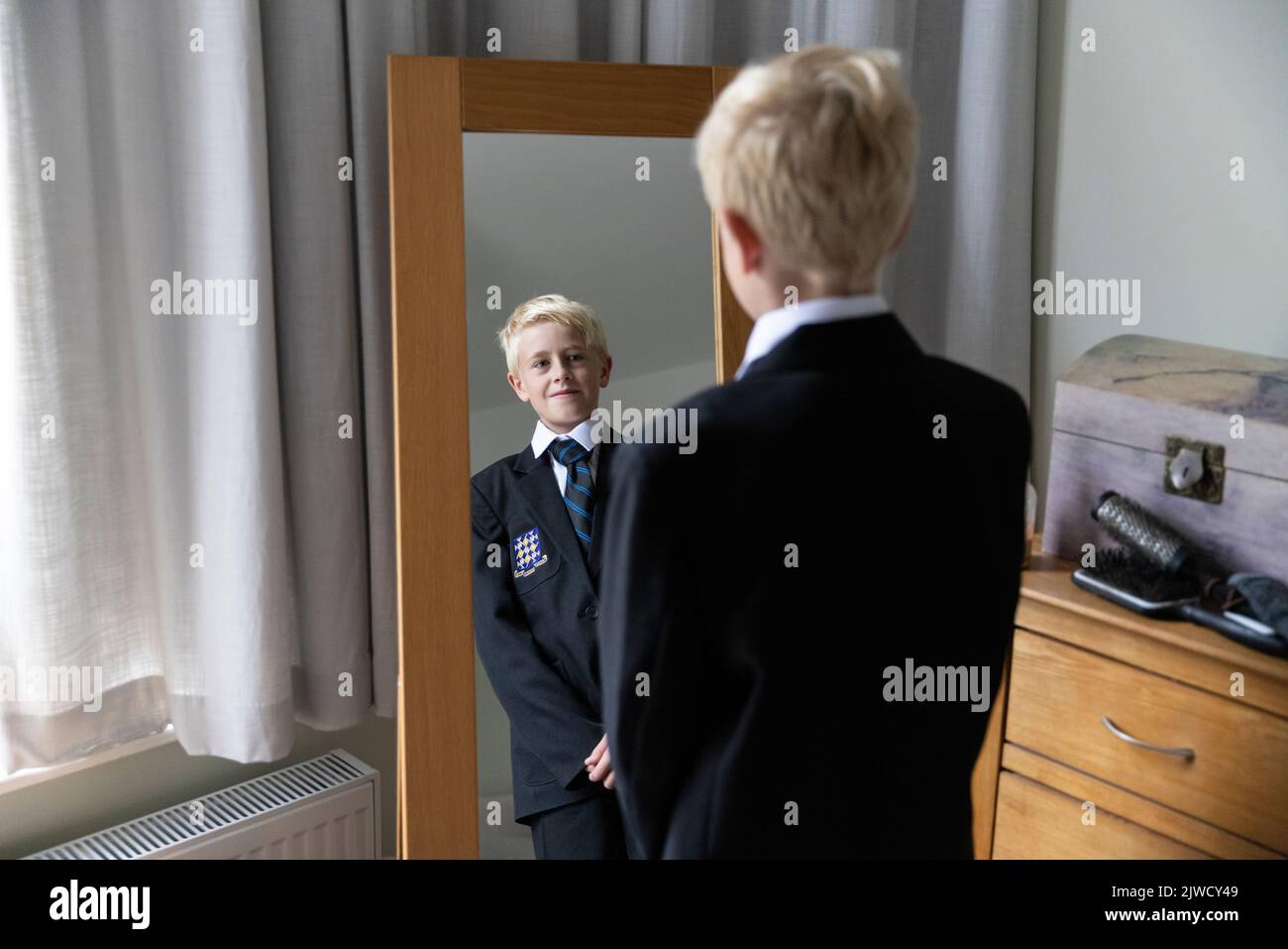Il primo giorno di ritorno a scuola, un ragazzo si prepara nella sua nuova divisa prima del suo primo giorno alla scuola secondaria, Inghilterra, Regno Unito Foto Stock