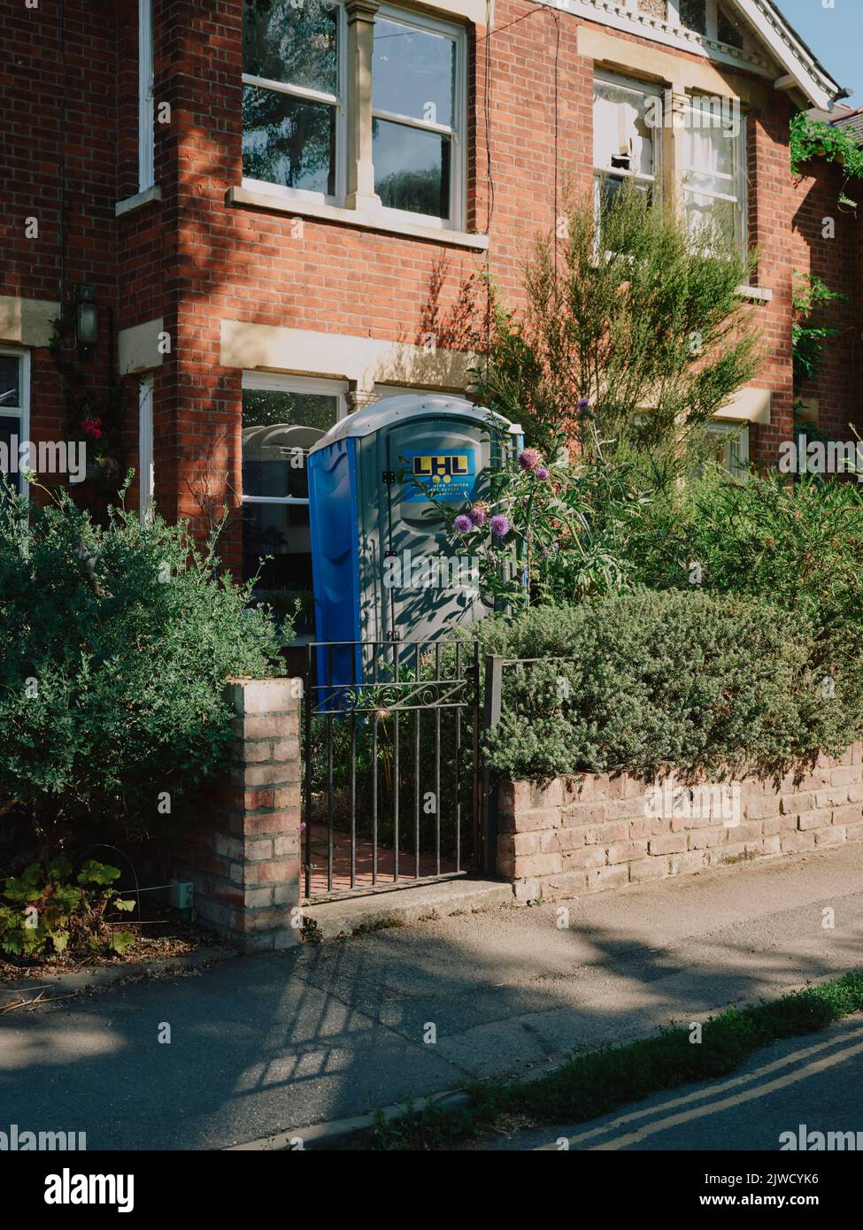 servizi igienici esterni in un piccolo giardino di fronte su una strada terrazzata. Foto Stock