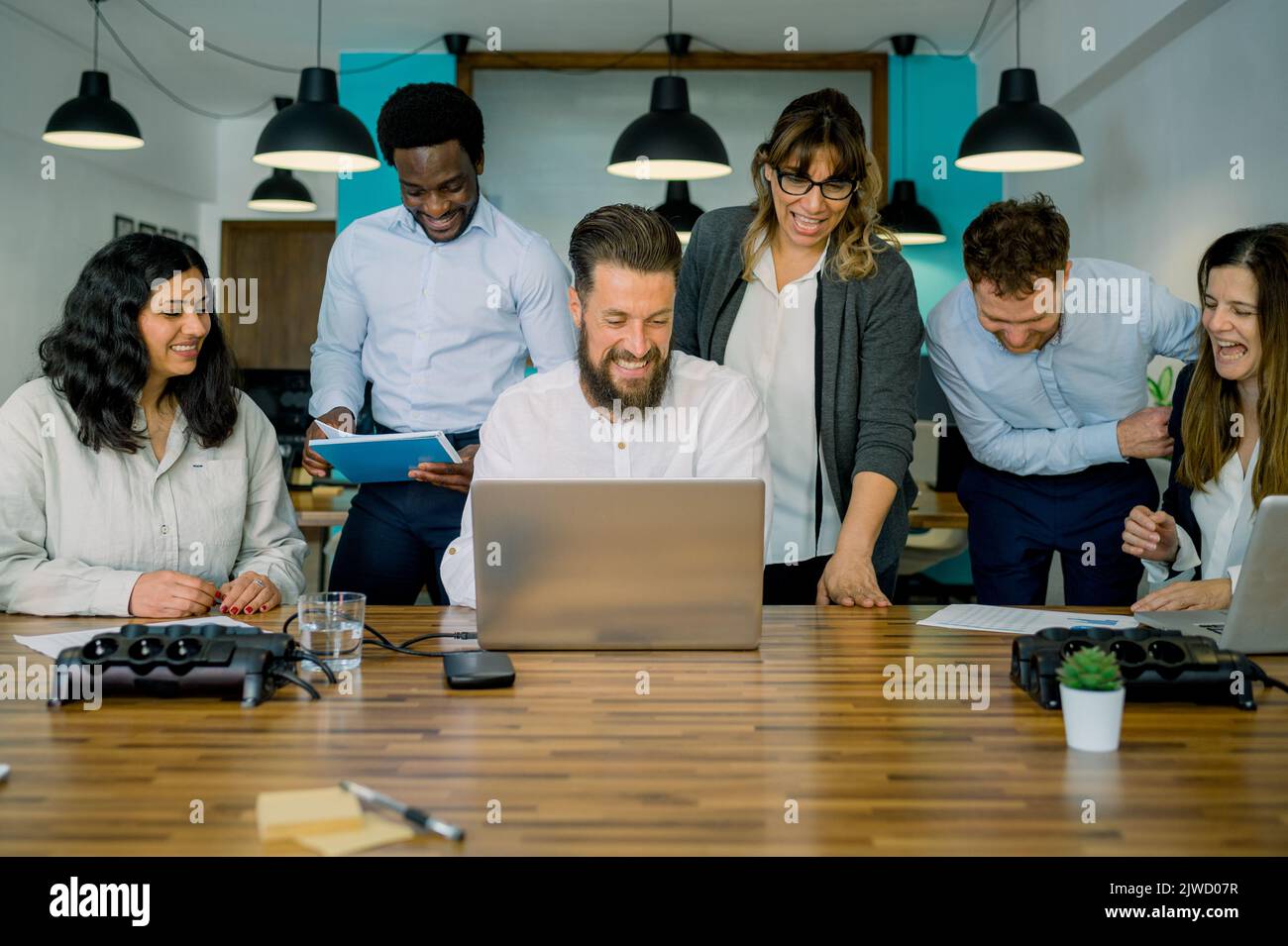 Felici diversi colleghi sorridenti durante la discussione di lavoro in ufficio Foto Stock