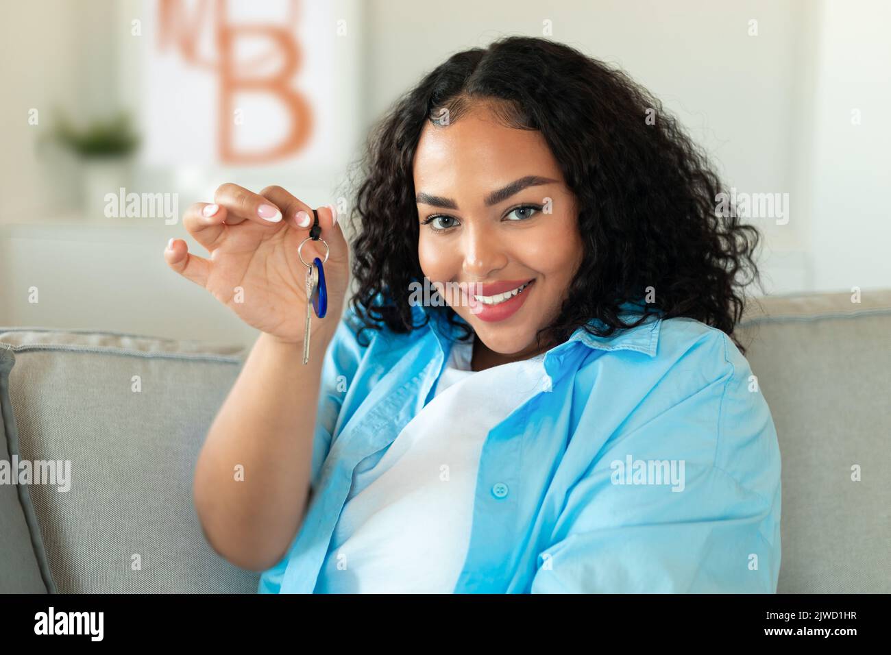 Donna nera felice che mostra la nuova chiave della casa a casa Foto Stock