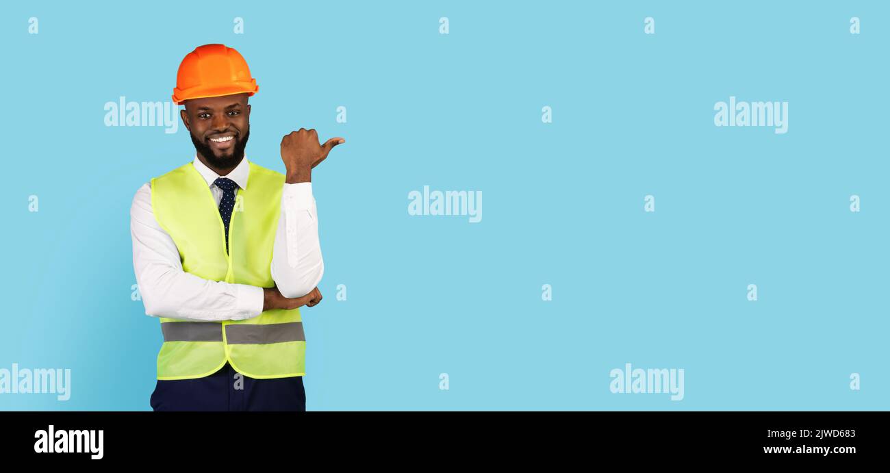 Bella offerta. Sorridendo Black Civil Engineer che indica da parte Copy Space Foto Stock