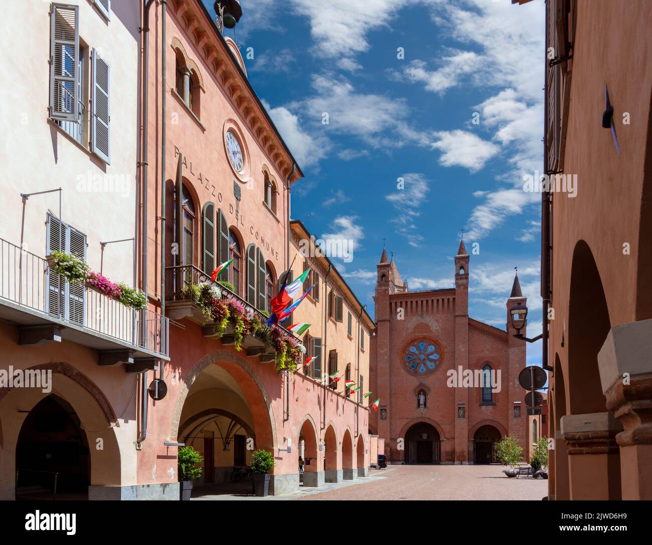Alba, Langhe, Piemonte, Italia - 16 agosto 2022: Il Municipio con balconi fioriti e portici medievali in via Cavour, sullo sfondo Cattedrale Foto Stock