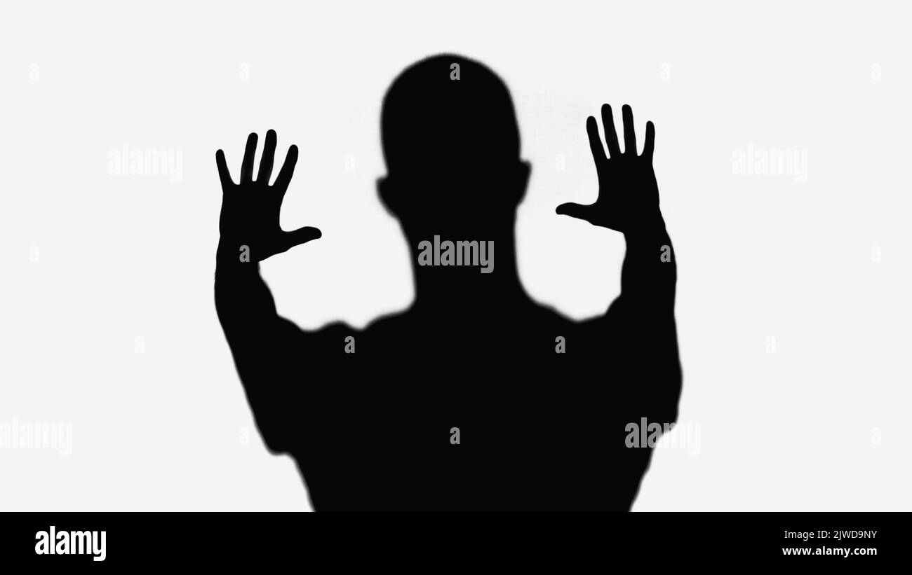 silhouette nera dell'uomo che mostra un gesto di stop isolato sul bianco Foto Stock