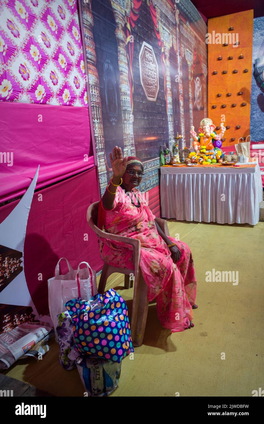 Mumbai, India, 03 Sep 2022 - una vecchia signora davanti a un bellissimo idolo di Lord Ganesha in un mandal a Mumbai per Ganesh Chaturthi Foto Stock