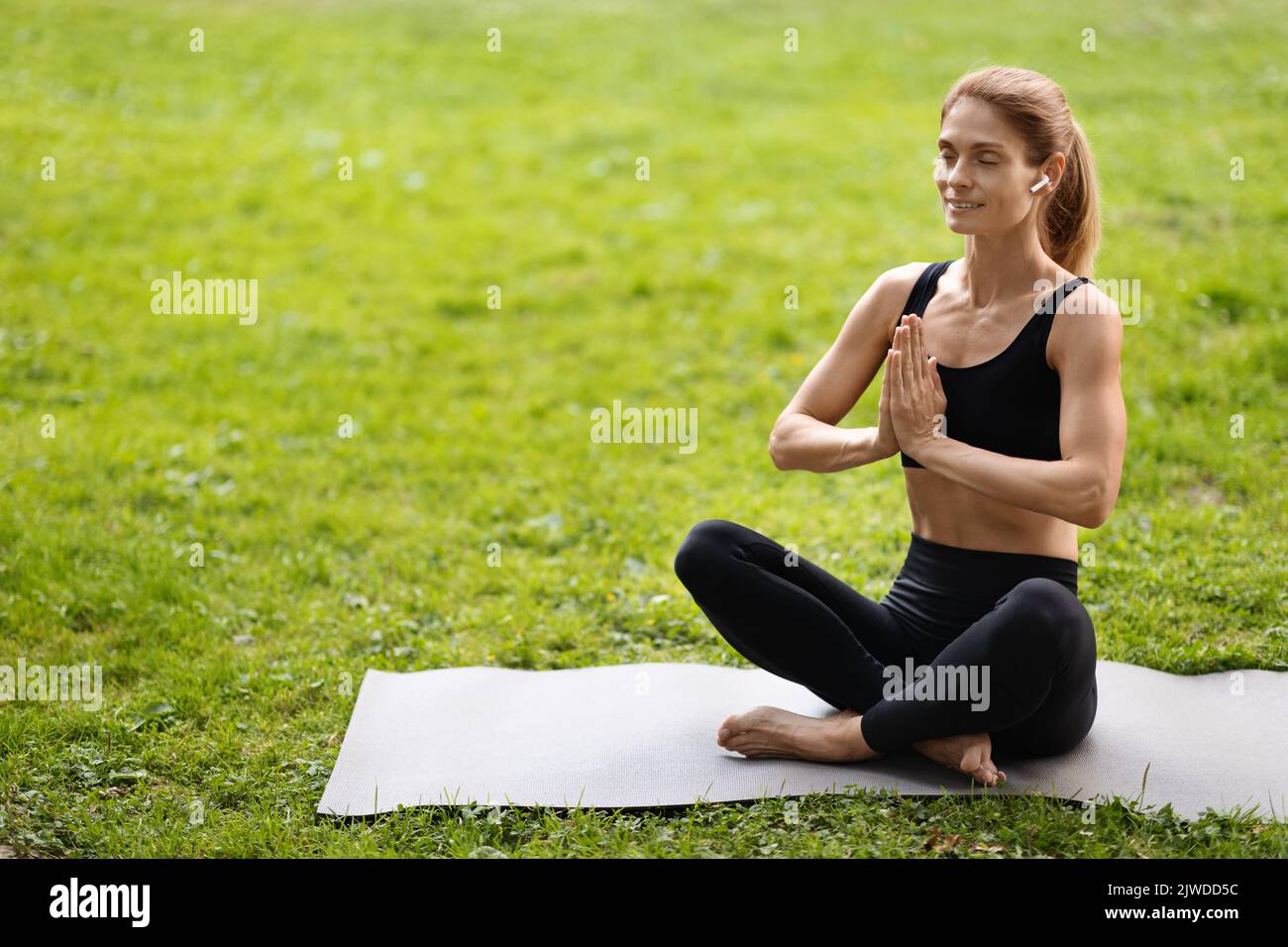 Donna yoga di mezza età che pratica all'aperto, spazio copia Foto Stock
