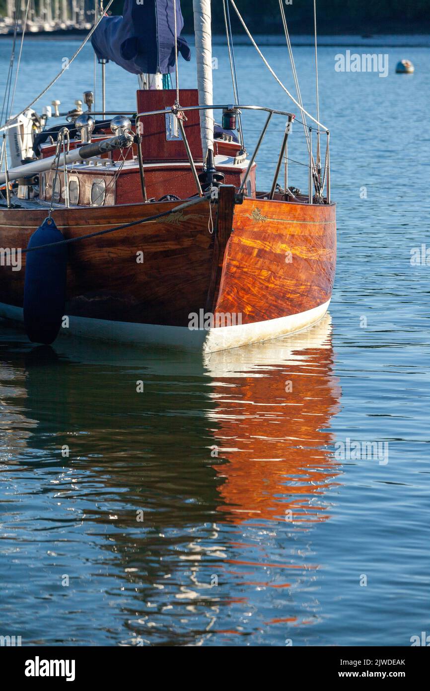 Riflessi sull'acqua di una classica barca a vela in legno nel porto di Dartmouth. Foto Stock