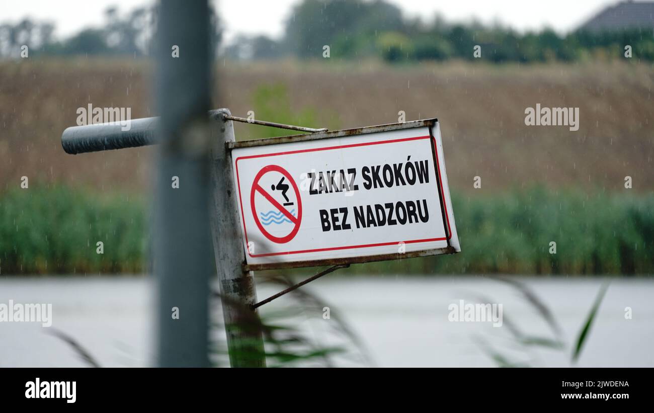 Segno polacco 'Zakaz skoków bez nadzory' zakaz skoków do wody. Foto Stock
