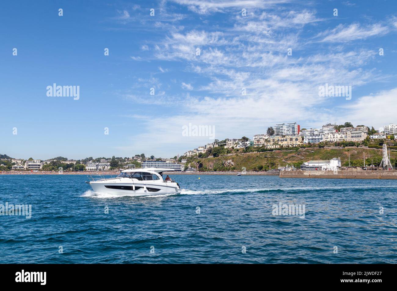 Un incrociatore a motore che si allontana da Torquay in una bella giornata estiva. Foto Stock