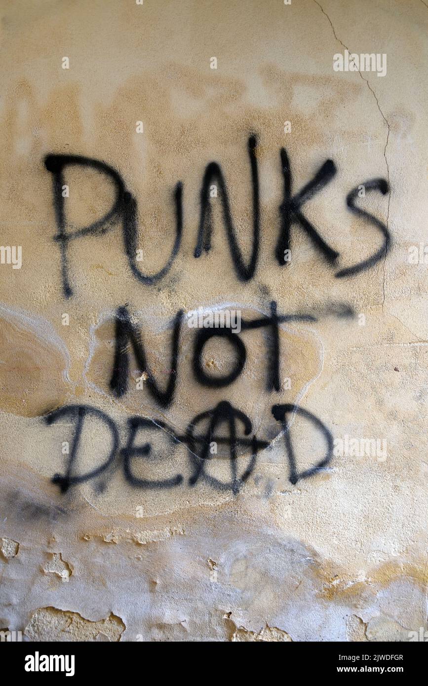 Punks non Dead Anarchy o slogan anarchico o Graffiti sulla vecchia parete degradata o facciata danneggiata Foto Stock
