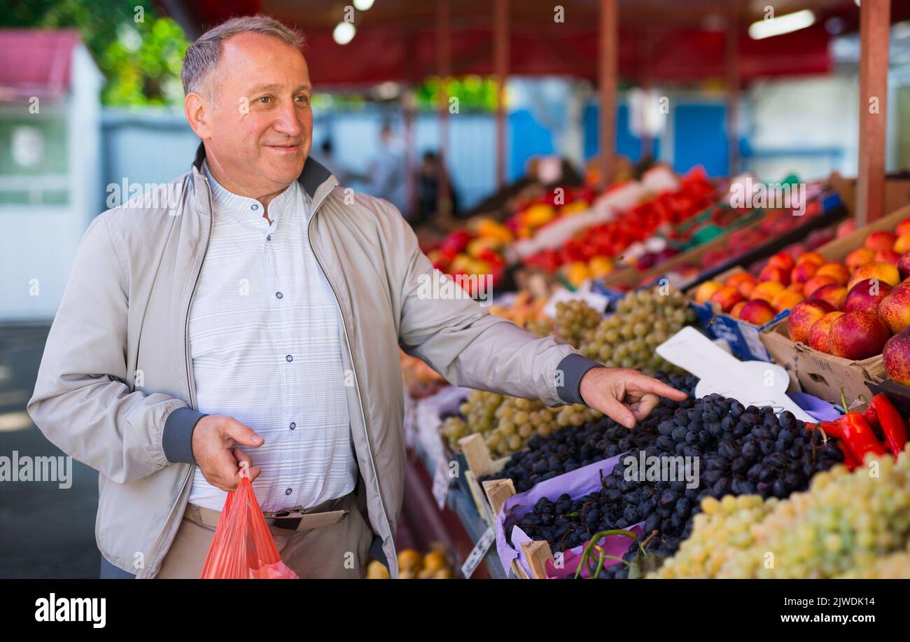 Uomo di mezza età che acquista frutti Foto Stock