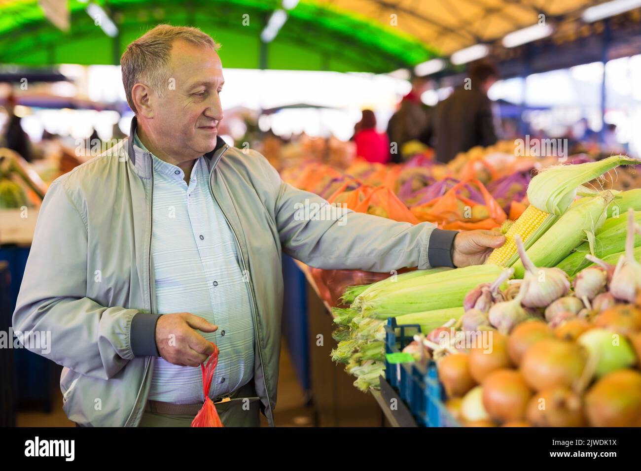 Uomo di mezza età che acquista verdure Foto Stock