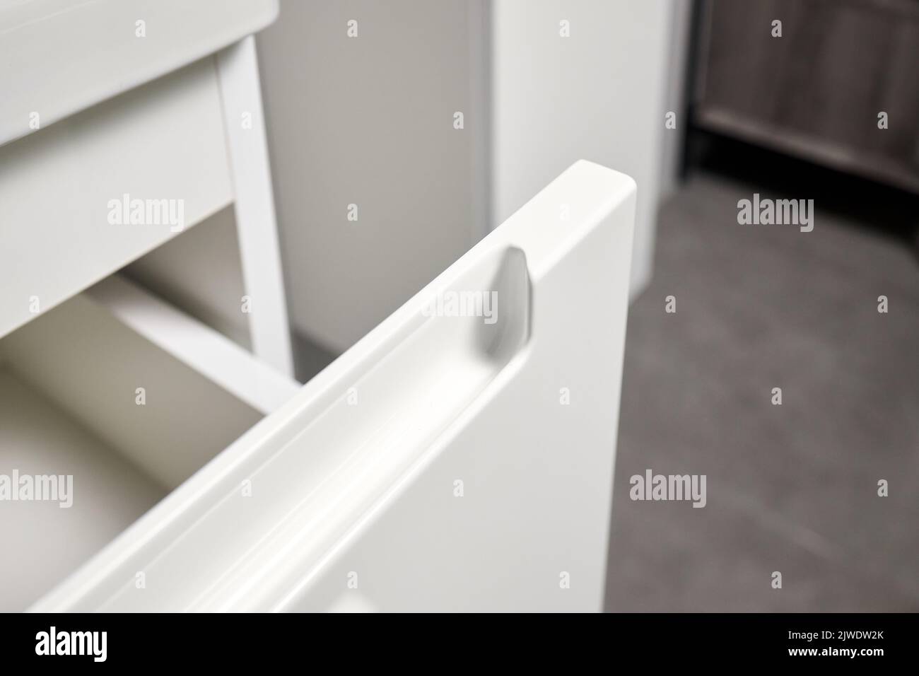 Soluzione per posizionare utensili da cucina in cucina moderna - orizzontale scorrevole estraibile scaffali cassetto in plastica stoccaggio con maniglia closeup in armadio Foto Stock