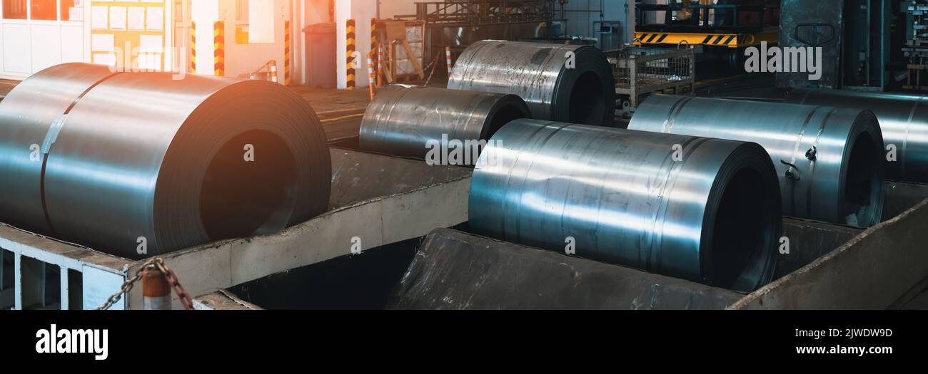 Rotoli di lamiere di acciaio. Bobine metalliche in officina di fabbrica di metalli. Foto Stock