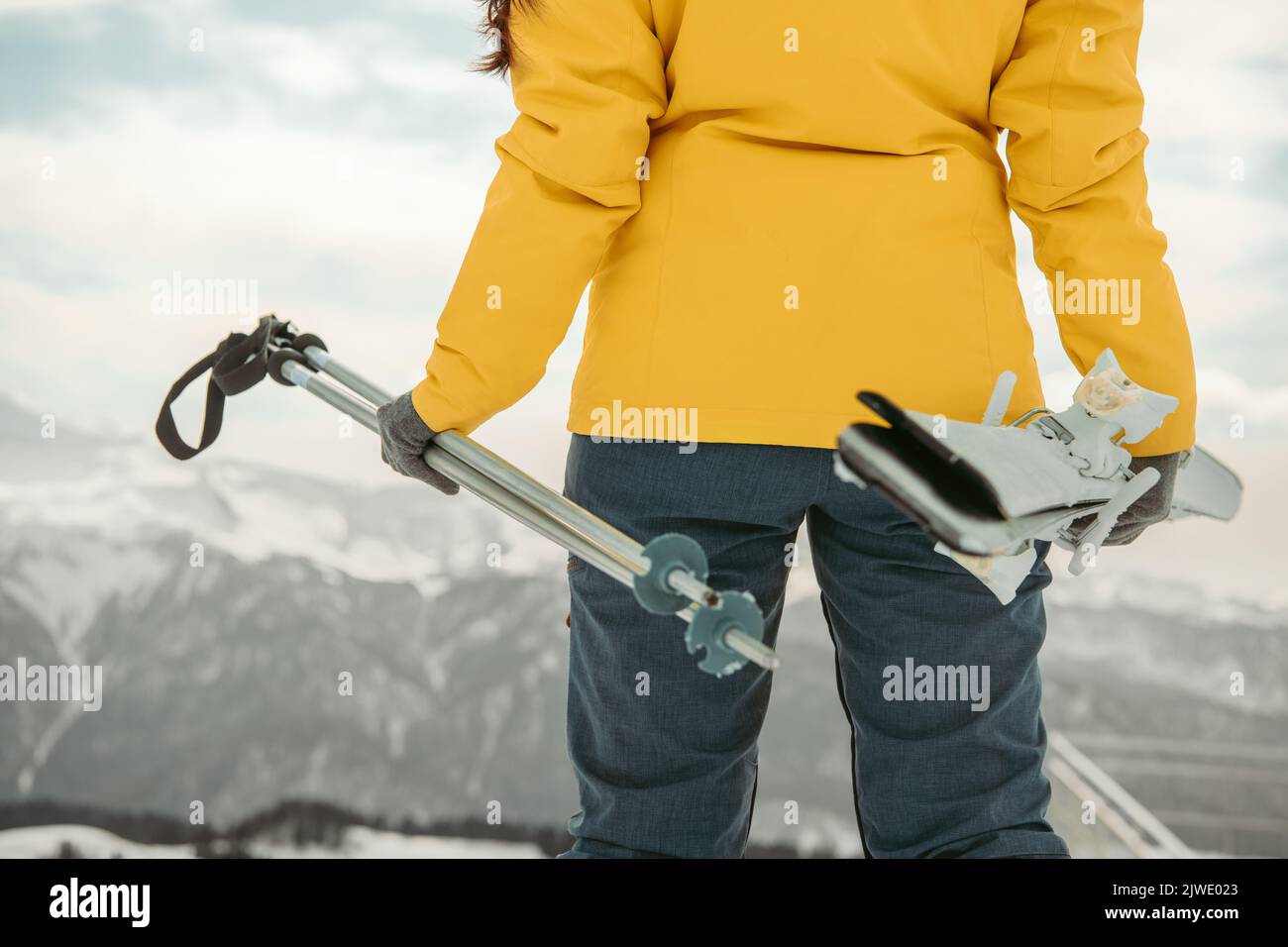 Primo piano di una sciatrice femminile che tiene in mano lo sci. Concetto di vacanza invernale Foto Stock