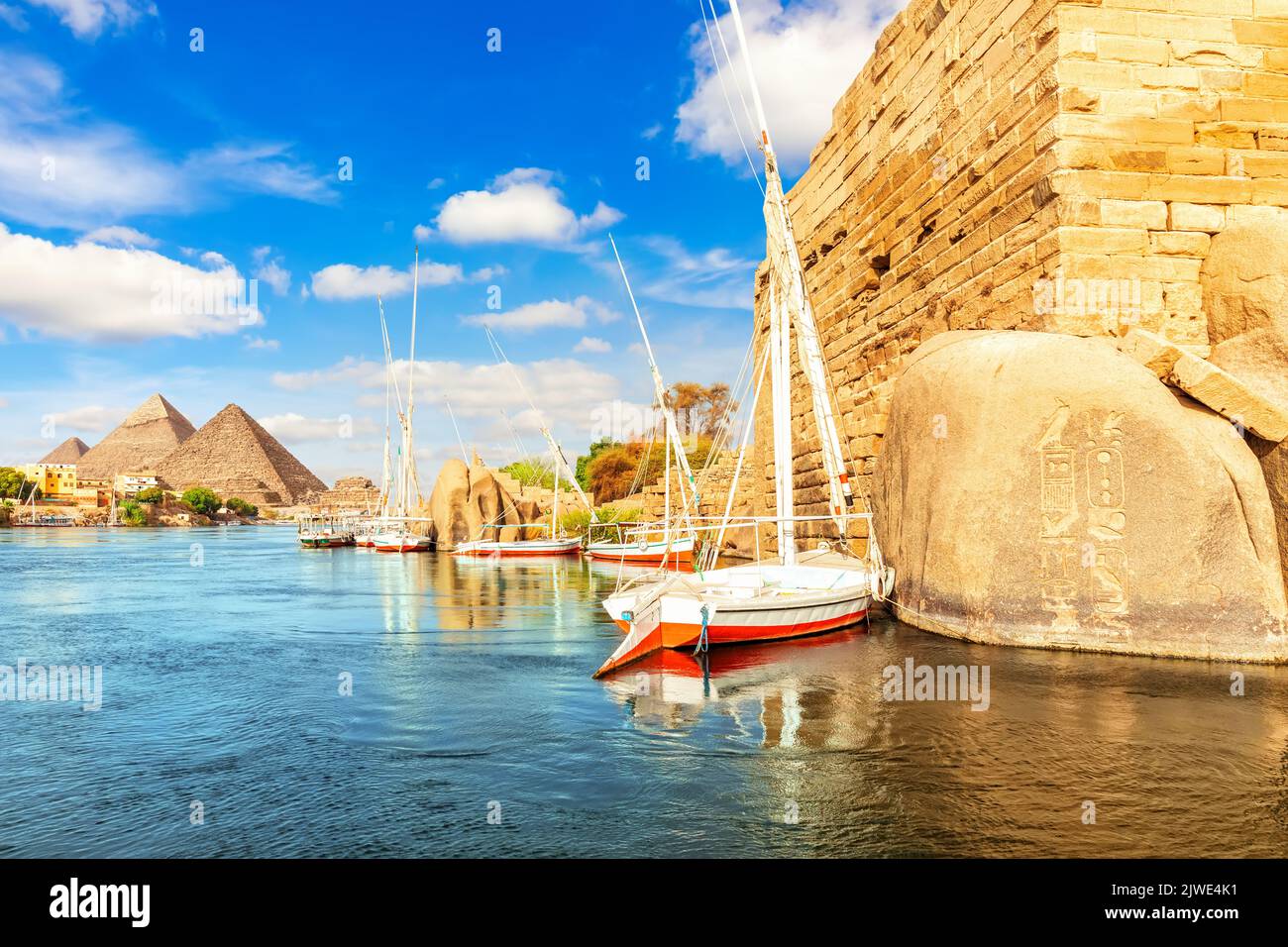 Barche a vela vicino alle rocce antiche sulla riva del Nilo, Assuan, Egitto Foto Stock