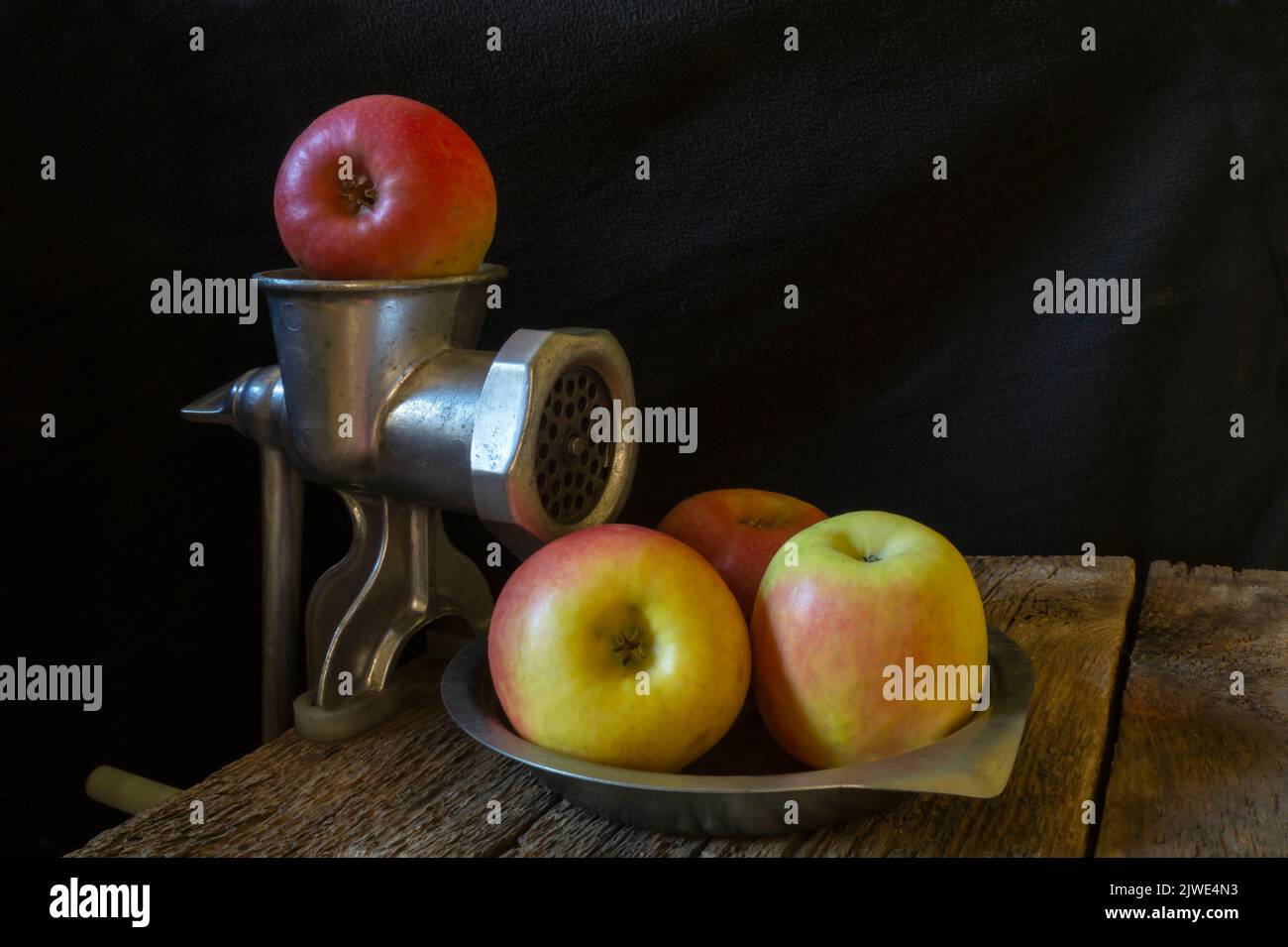 Vita ferma con attrezzature da cucina e frutta matura. Primo piano su sfondo nero Foto Stock