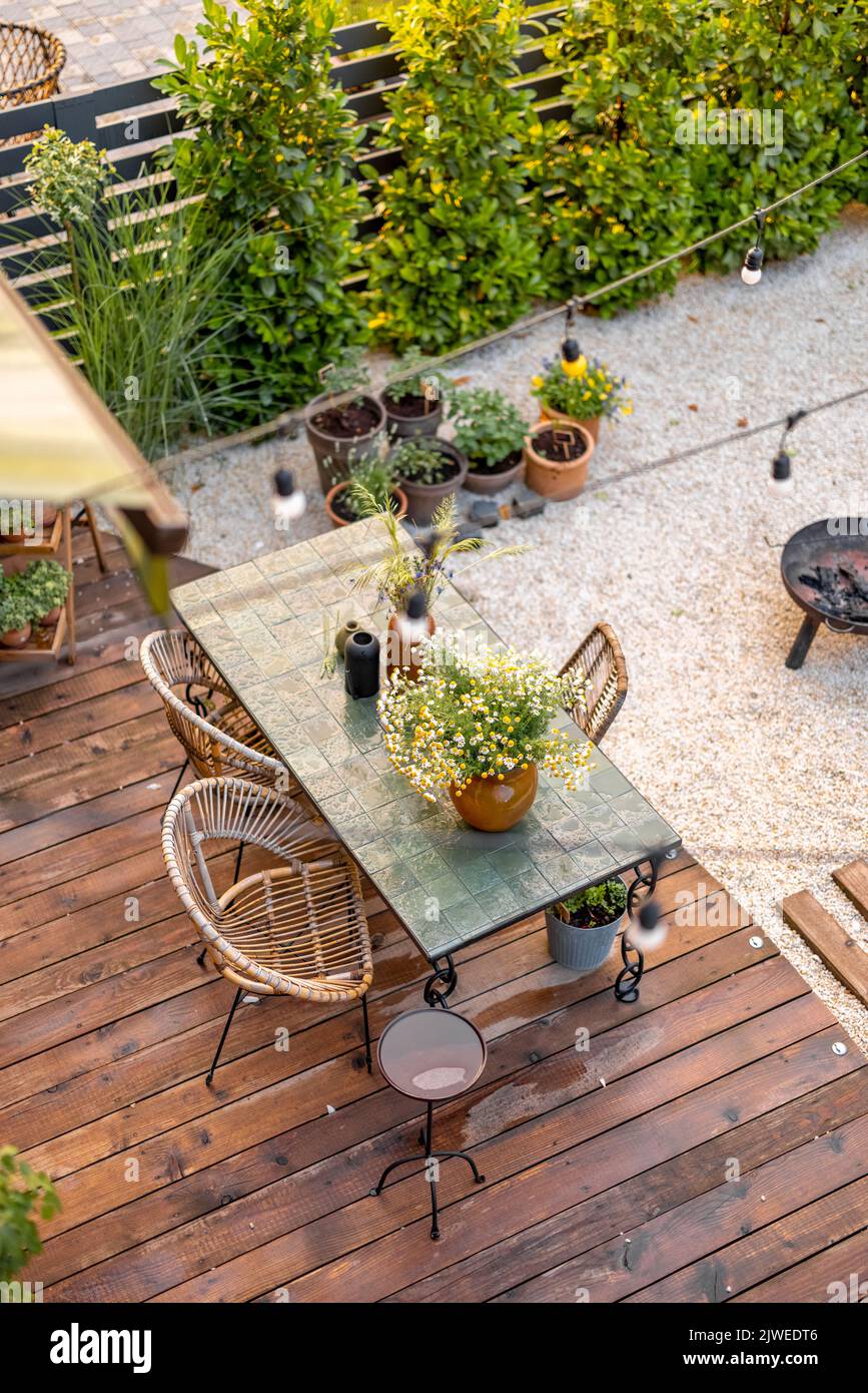 Cortile accogliente con bella sala da pranzo su terrazza in legno Foto Stock