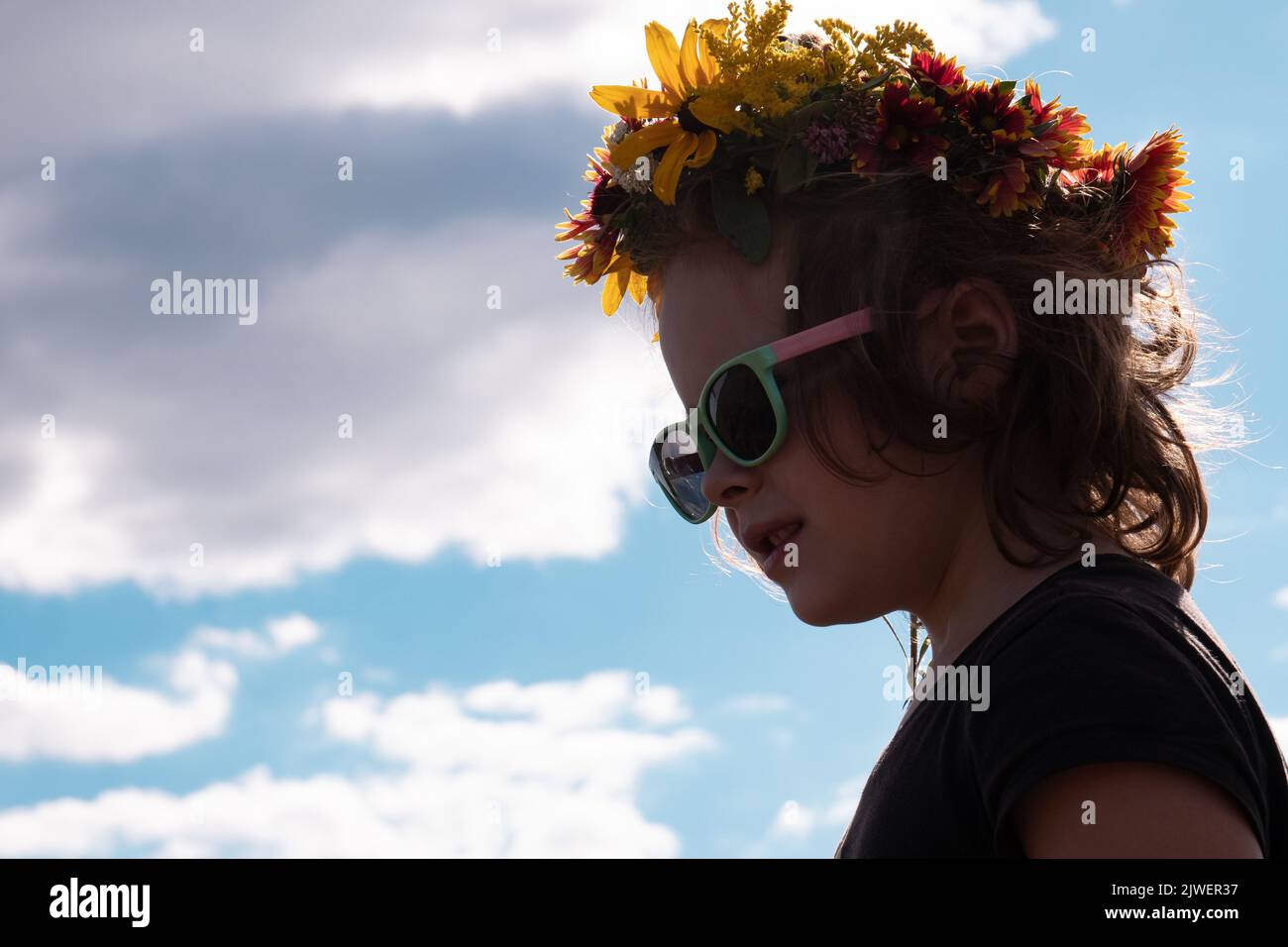 faccia ragazza 5 anni in occhiali da sole neri contro il cielo, tempo estivo concetto di spazio copia. Foto Stock