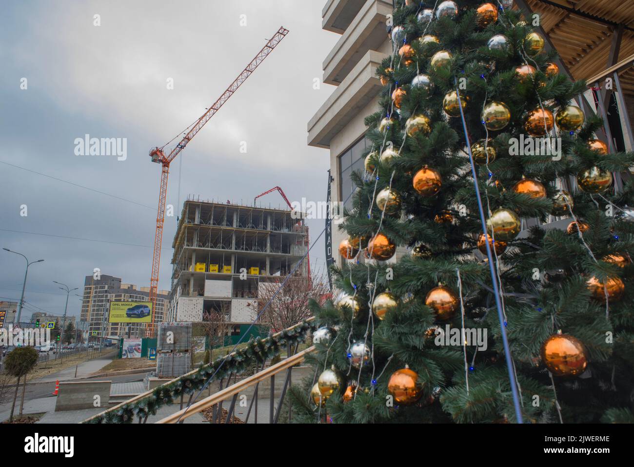 Decorato albero di Natale, e sito di costruzione sullo sfondo, a Kharkiv, Ucraina Foto Stock