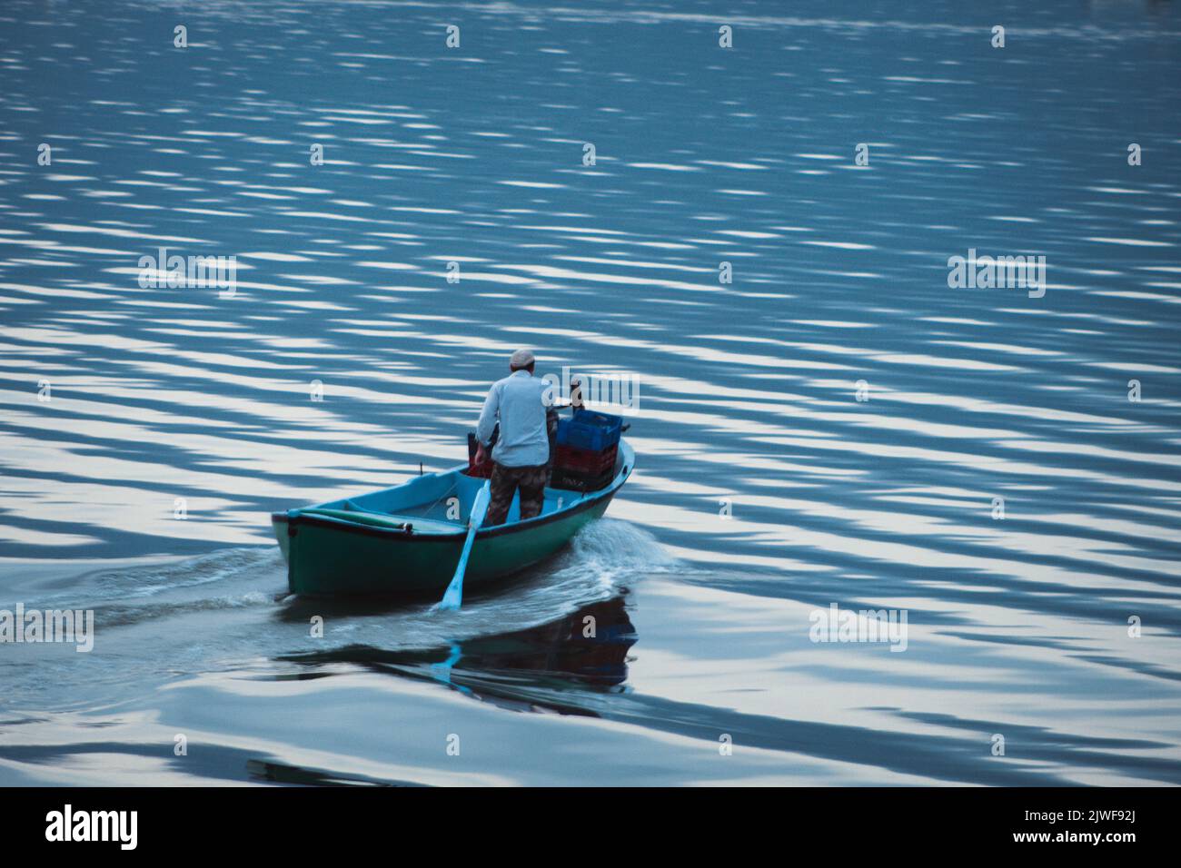 Golyazi, Bursa - 2022 agosto: I pescatori nel lago vanno a pescare con le loro barche al mattino presto, fuoco selettivo Foto Stock